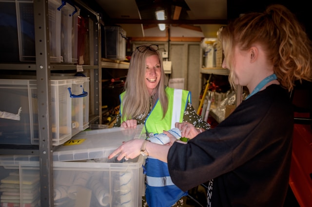 A woman kitting items in a warehouse.