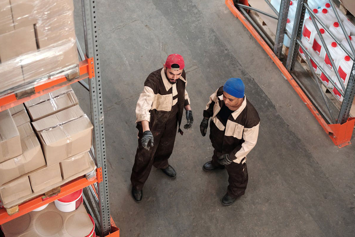 Two men in a warehouse talking.