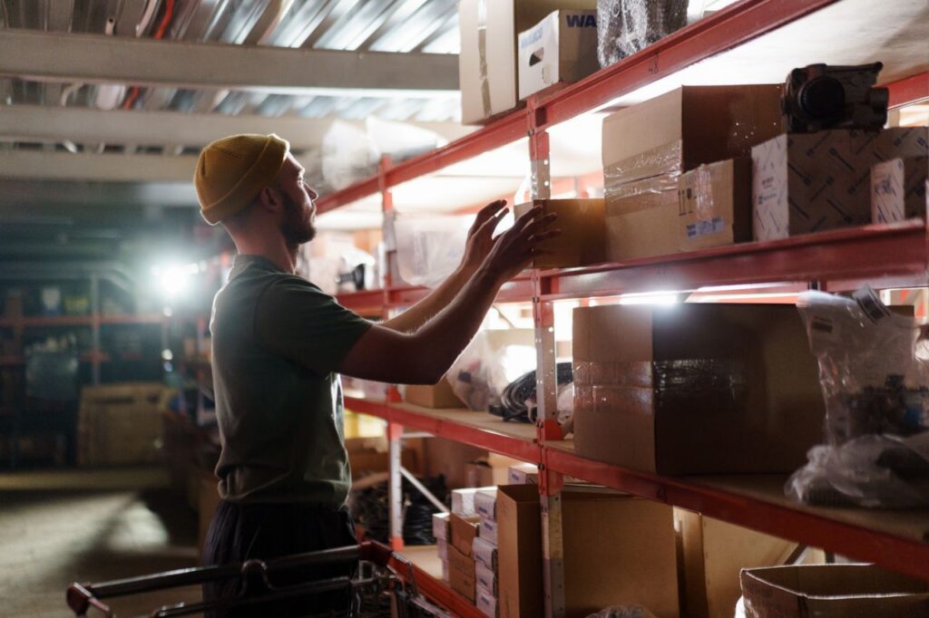 A man organizing boxes on a warehouse shelf