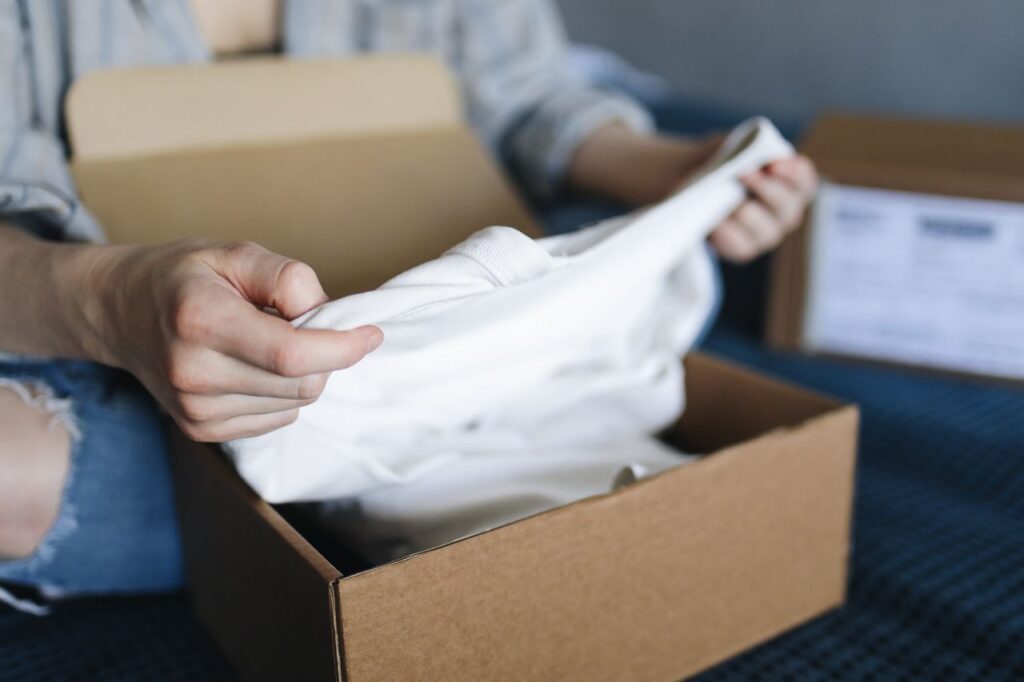 A person taking a garment out of a box