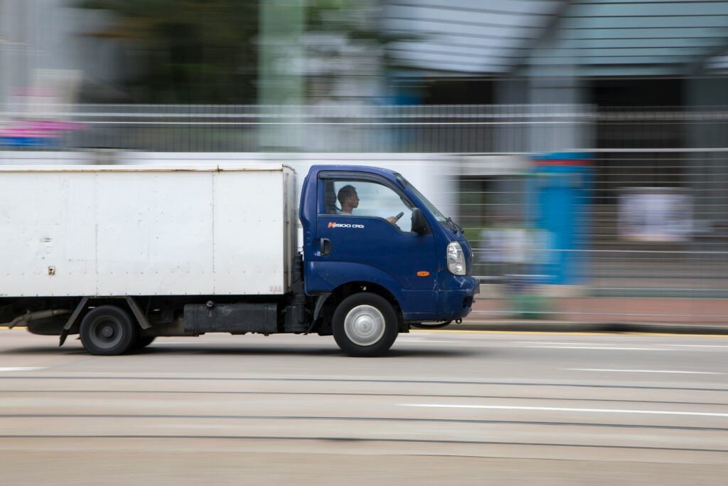 A blue and white van on a road.